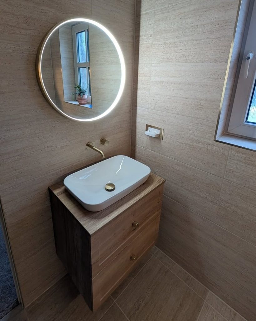 Vessel basin on a wall-hung oak vanity with a round LED mirror in a Paisley en-suite
