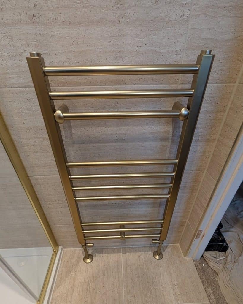Brushed brass heated towel rail in a Paisley en-suite